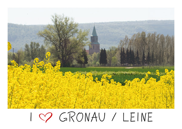 Postkarte mit dem Schriftzug I love Gronau und einem Bild eines Rapsfeldes und der Kirche im Hintergrund